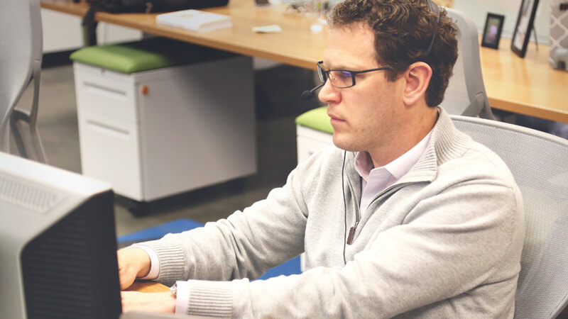 Man sat at a Desk with Headset